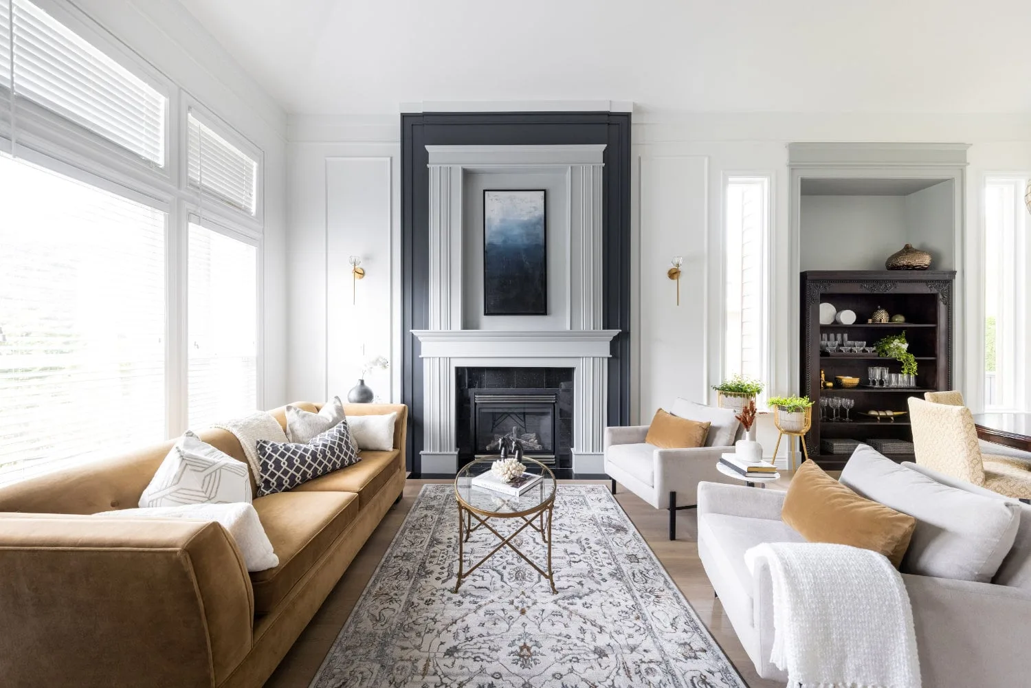 The living room, with a panelled fireplace in a dark surround and a caramel sofa.