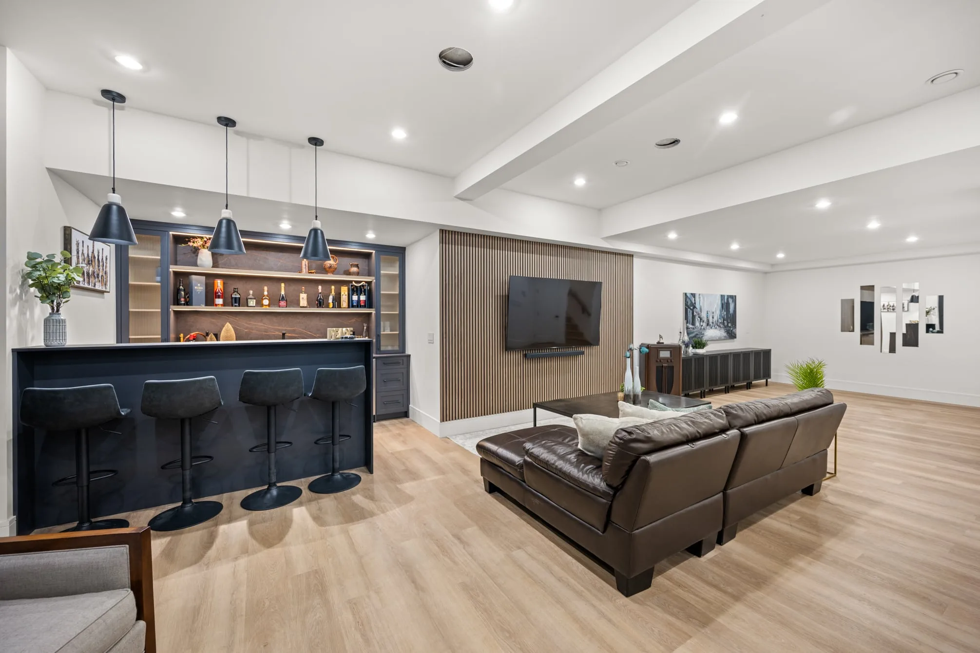 The wet bar, with navy cabinets and pendants beside the lounge.