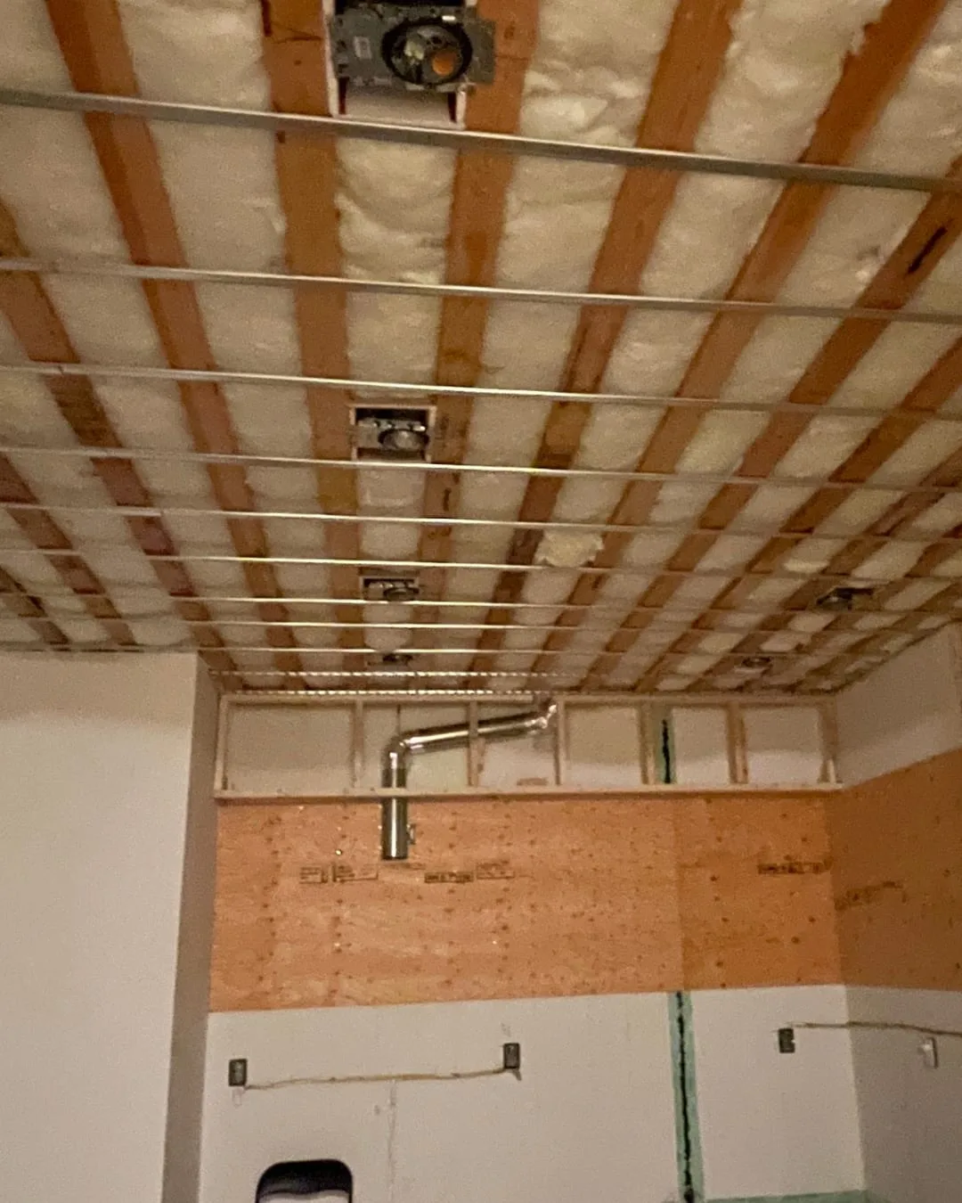 Before: open joists, insulation and ductwork overhead, before the ceiling closed in.